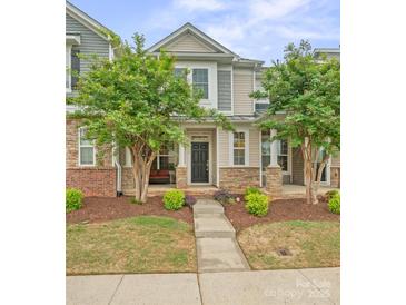 Charming two-story home with a well-manicured lawn and inviting front porch with stone accents and trees at 233 E Waterlynn Rd # B, Mooresville, NC 28117