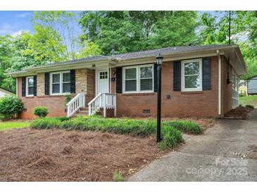 Charming brick home with black shutters, white trim, and well-maintained landscaping offers curb appeal at 3733 Manchester Dr, Charlotte, NC 28217