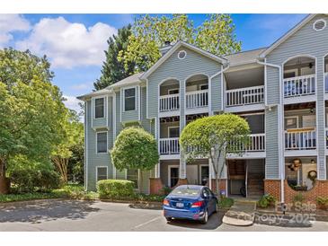 Charming condo with balconies, complemented by well-maintained landscaping and a blue car parked nearby at 430 Queens Rd # 111, Charlotte, NC 28207