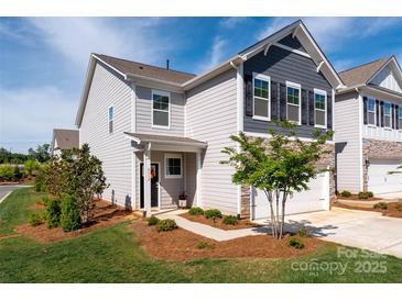 Charming two-story home with gray siding, stone accents, a well-manicured lawn, and a one-car garage at 4312 Plumeria Way, Fort Mill, SC 29707