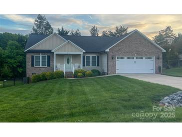Charming brick and vinyl home with well-maintained lawn and attached two-car garage at 506 E Pine St, Maiden, NC 28650