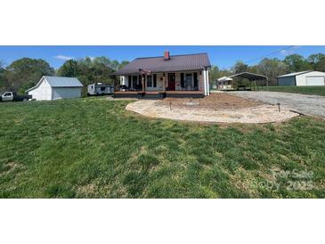 Charming home with a metal roof, covered front porch, and well manicured yard at 548 Alspaugh Dam Rd, Taylorsville, NC 28681