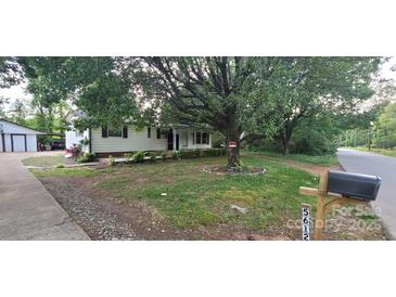 Charming single-story home with a covered front porch and mature trees providing shade at 5612 Henderson Cir, Charlotte, NC 28269