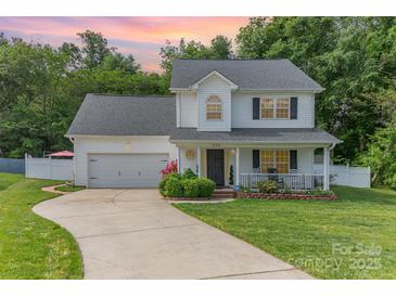 Charming two-story traditional home with inviting front porch and manicured lawn on a landscaped lot at 636 Sadler Glen Dr, Charlotte, NC 28214