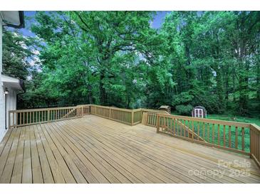 Spacious back deck overlooks wooded backyard with shed and mature trees at 7531 Linda Lake Dr, Charlotte, NC 28215