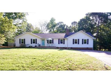 Charming one-story home featuring a well-manicured lawn and a inviting blue front door, creating a welcoming curb appeal at 854 Silver Fox Dr, Concord, NC 28025