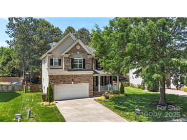 Beautiful two-story home featuring a brick facade, attached garage, and well-manicured front yard at 1011 Master Gunner Ct, Indian Trail, NC 28079