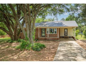 Charming single-story brick home with a mature shade tree in a suburban setting at 102 Erwin St, Chester, SC 29706