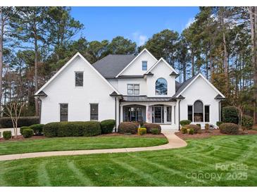 Beautiful white brick home with lush lawn and mature trees at 107 Waterhouse Ct, Mooresville, NC 28117
