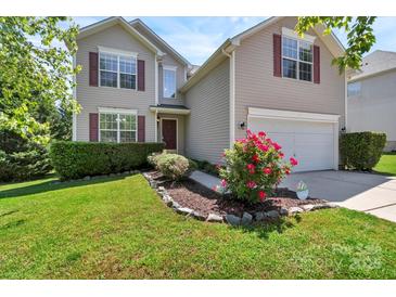 Charming two-story home with red shutters, a well-manicured lawn, and a beautiful flower bed at 1218 Faversham Ln, Rock Hill, SC 29730