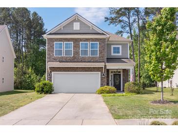 Charming two-story home with stone accents, attached garage and well-manicured lawn at 2214 Laurens Dr, Concord, NC 28027