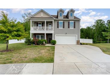 Charming two-story home with a welcoming front porch, attached garage, and well-maintained landscaping at 6040 Fazio Ct, Harrisburg, NC 28075
