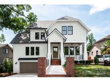 Charming two-story home showcasing a white exterior, black trim windows, and a welcoming front porch at 632 Dorothy Dr, Charlotte, NC 28203