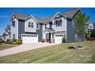 Charming home with a three-car garage, stone accents, manicured lawn, and mature landscaping at 990 Nw Capwalk Nw Rd # 138, Concord, NC 28027