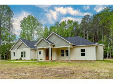 Beautiful, newly built home with a manicured lawn and a well-lit porch at 108 Woodwinds St, Locust, NC 28097