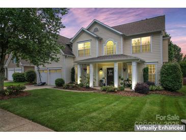 Charming two-story home featuring a manicured lawn and inviting front porch with classic columns at 125 N Wendover Trce, Mooresville, NC 28117
