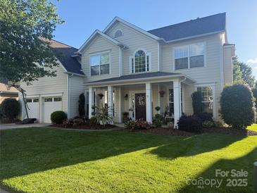 Charming two-story home with a beautifully landscaped front yard and welcoming front porch with columns at 125 N Wendover Trce, Mooresville, NC 28117