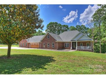 Charming single-story brick home featuring a well-manicured lawn and a welcoming front porch with a white railing at 3009 Brooks Mill Ln, Wingate, NC 28174