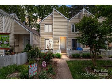 Charming townhome with a picket fence, lush garden, and a welcoming walkway to the front door at 407 Eastwood Dr, Salisbury, NC 28146