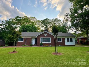Charming brick home with manicured lawn, mature trees, and a welcoming front entrance at 4448 Halstead Dr, Charlotte, NC 28209