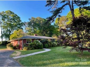 Charming brick home with lush landscaping and a well-maintained lawn at 5209 Markay St, Matthews, NC 28105
