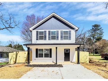 New construction two-story home with gray and white color scheme, black shutters, a covered front porch, and newly seeded lawn at 624 W Kerr St, Salisbury, NC 28144