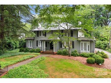 Charming two-story home with a beautifully landscaped front yard and mature trees at 920 Queens Rd, Charlotte, NC 28207