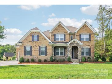 Beautiful two-story brick home with a stone entryway and well-maintained landscaping at 1004 Princesa Dr, Matthews, NC 28104