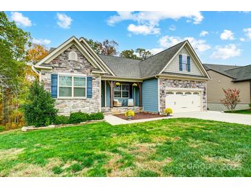 Charming home with stone accents, blue shutters, manicured lawn, and an attached two-car garage at 1150 Hearth Sw Ln, Concord, NC 28025