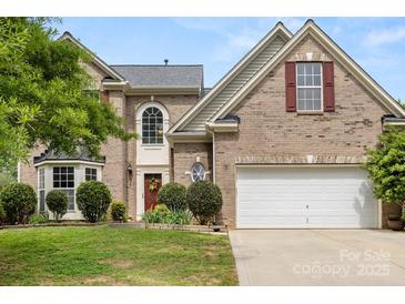 Charming brick home with a well-manicured lawn and attached two-car garage, perfect for families at 124 Shephard Hill Dr, Mooresville, NC 28115