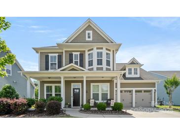 Charming two-story home featuring manicured landscaping, a welcoming front porch, and an attached two-car garage at 1963 Felts Pkwy, Fort Mill, SC 29715