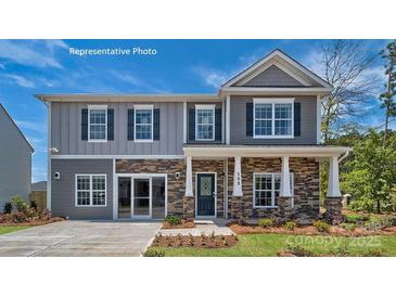 Two story home featuring gray siding, stone accents, dark shutters and an inviting front porch at 215 Giant Oak Ave, Statesville, NC 28677