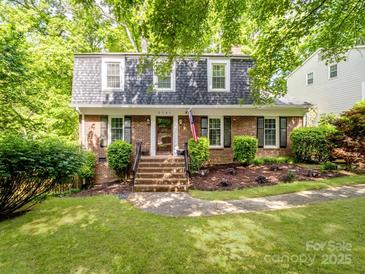 Charming brick home with manicured lawn, mature trees, and a welcoming front entrance at 2731 Creekbed Ln, Charlotte, NC 28210