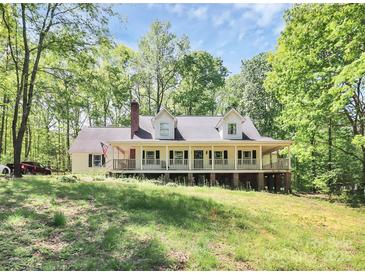 Charming home with a large covered front porch, nestled among mature trees, exudes southern comfort at 2780 China Grove Rd, Kannapolis, NC 28083