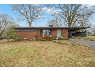 Charming brick home with a covered carport and a cozy front porch, set in a tranquil tree-lined neighborhood at 401 Clover Ln, Newton, NC 28658