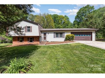 Split-level home boasts a well-maintained lawn, brick accents, and attached two-car garage at 503 Randa Dr, Statesville, NC 28625