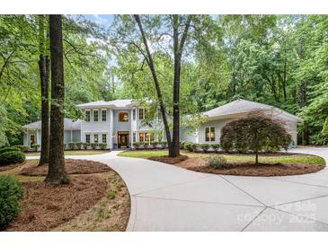 Charming traditional home with a circular driveway, lush landscaping, and mature trees at 6868 St Peters Ln, Matthews, NC 28105