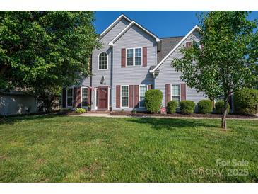 Charming two-story home with well-maintained lawn, mature trees, and classic architectural details at 7905 Sedgebrook E Dr, Stanley, NC 28164