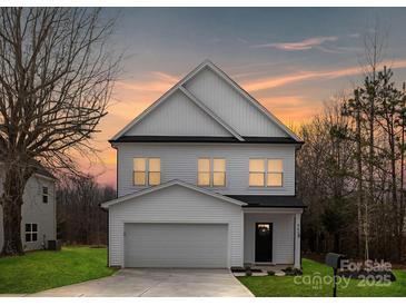 Charming two-story home with a garage and well-manicured lawn at sunset at 9423 Weston Woods Ln, Charlotte, NC 28216