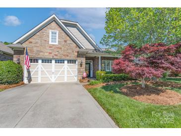 Charming home featuring a stone facade, two-car garage, and beautifully landscaped front yard at 11008 Round Rock Rd, Charlotte, NC 28277