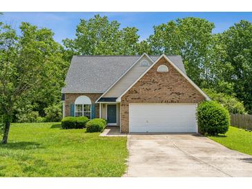 Charming brick and siding home with a two-car garage and well-manicured front lawn at 3038 Twin Peaks Ct, Monroe, NC 28110