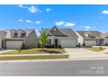 Charming single-story home with manicured lawn and two-car garage, perfect for suburban living at 329 Brambling Ct, Monroe, NC 28110