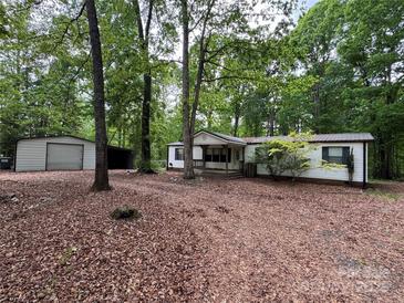 Charming single-story home with white siding, metal roof, and spacious front yard surrounded by mature trees at 351 Fletcher Rd, Union Grove, NC 28689