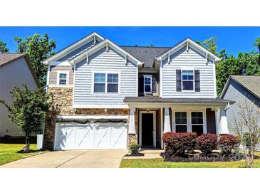 Charming two-story home featuring stone accents, gray siding, and a two-car garage at 413 Hunton Forest Dr, Concord, NC 28027