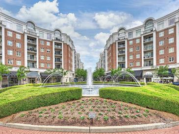 Beautiful Town Square with fountains, landscaping, and shops, surrounded by elegant buildings with balconies under a partly cloudy sky at 4625 Piedmont Row Dr # 701, Charlotte, NC 28210
