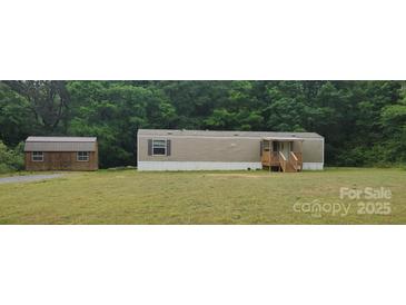 Charming single-story home with siding, a porch and a lush lawn surrounded by mature trees at 544 Bentley Rd, Shelby, NC 28152