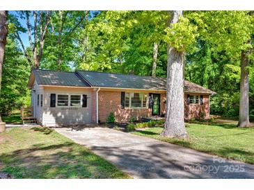 Charming brick home with a metal roof, a well-manicured lawn, and mature trees offering shade and curb appeal at 612 Summerow Rd # Lot 22, Stanley, NC 28164