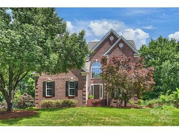 Beautiful brick home with a well-manicured lawn and mature trees at 6723 Joliette Ln, Charlotte, NC 28277
