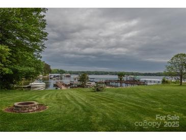 Expansive lake view with a well-manicured lawn, dock, and fire pit, perfect for outdoor entertaining at 7942 Vista View Dr, Sherrills Ford, NC 28673