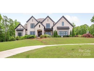 Stunning white brick home with a beautifully landscaped lawn and a long, curved walkway at 1045 Spyglass Ln, Waxhaw, NC 28173